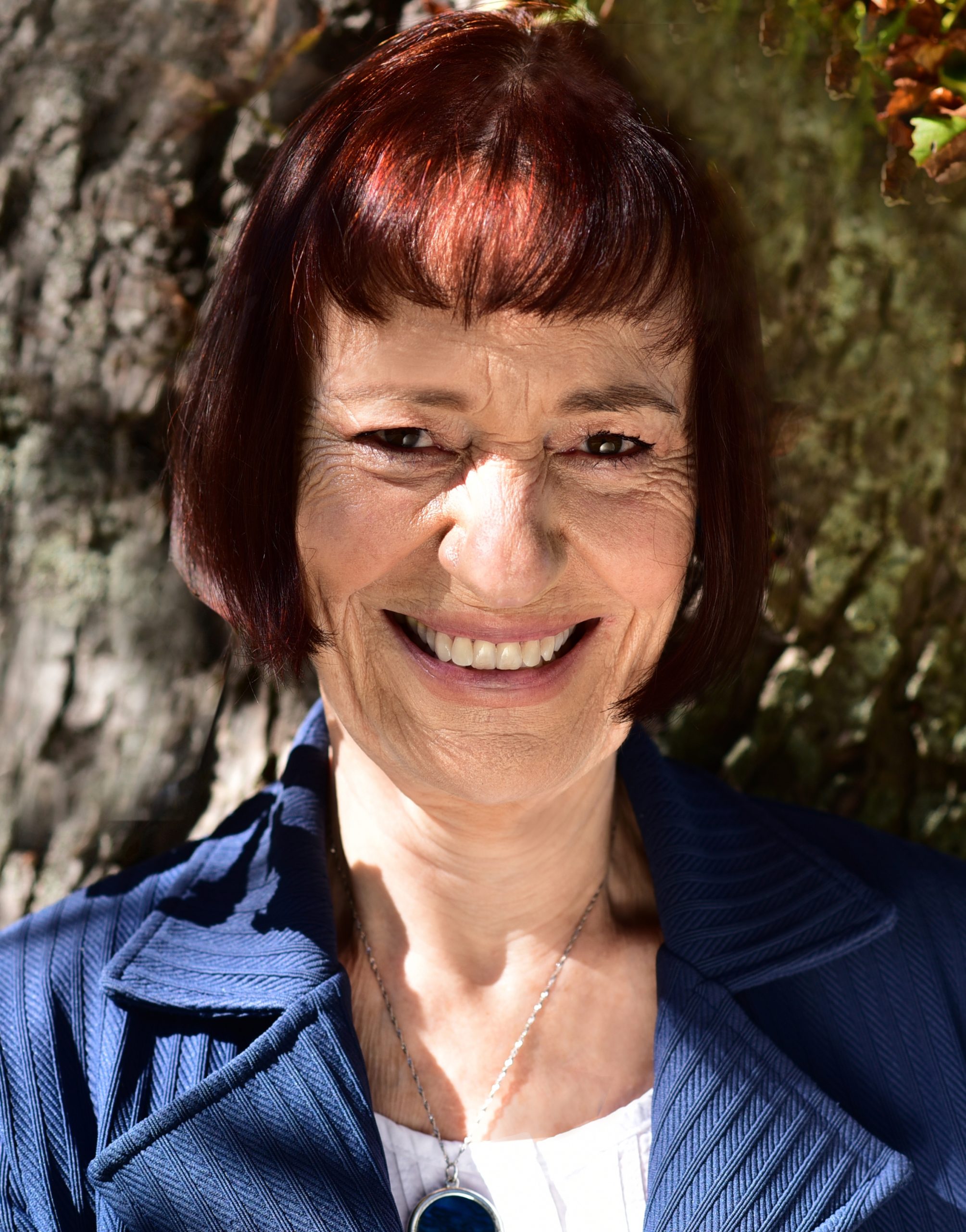 Photo of Dorothea Fuckert in front of a big tree trunk