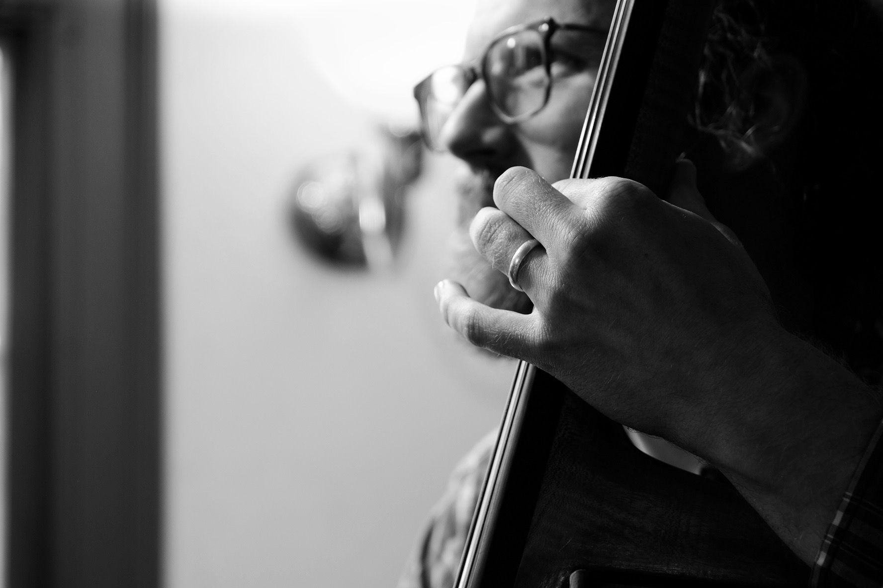 Photo of Evan Premo playing the bass, the focus is on his hand
